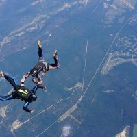 learn to skydive student flies receives hands-on attention from instructor in freefall