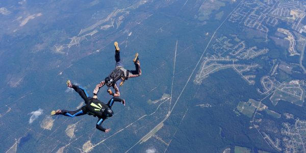 learn to skydive student flies receives hands-on attention from instructor in freefall