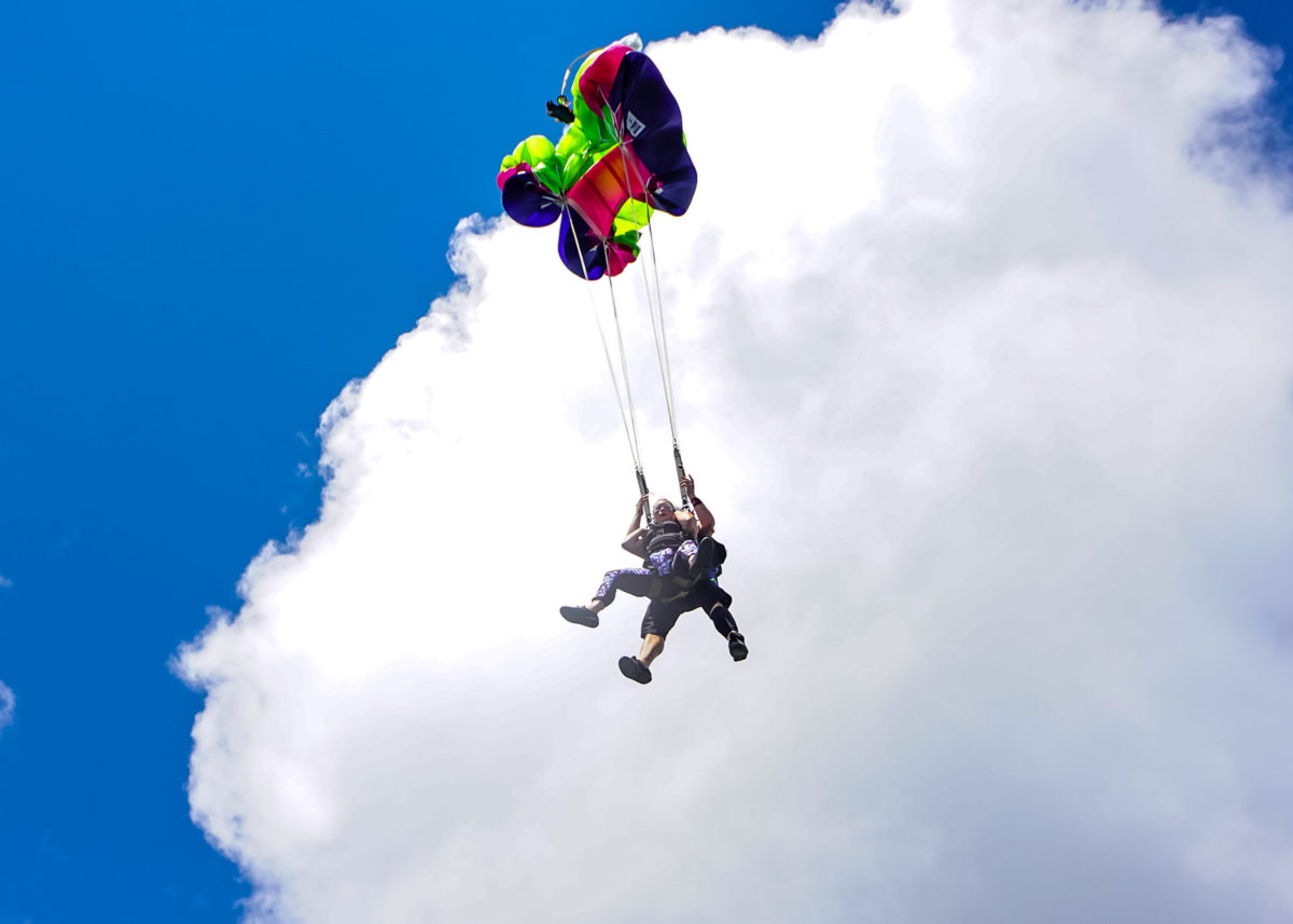 Tandem skydivers deploy parachute