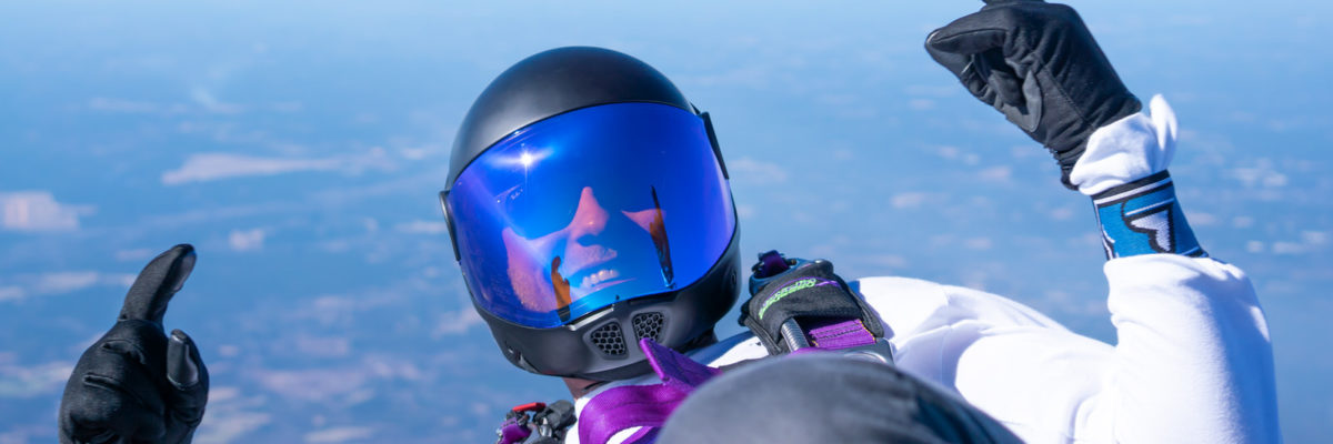 Skydiver back flying with blue face visor on helmet