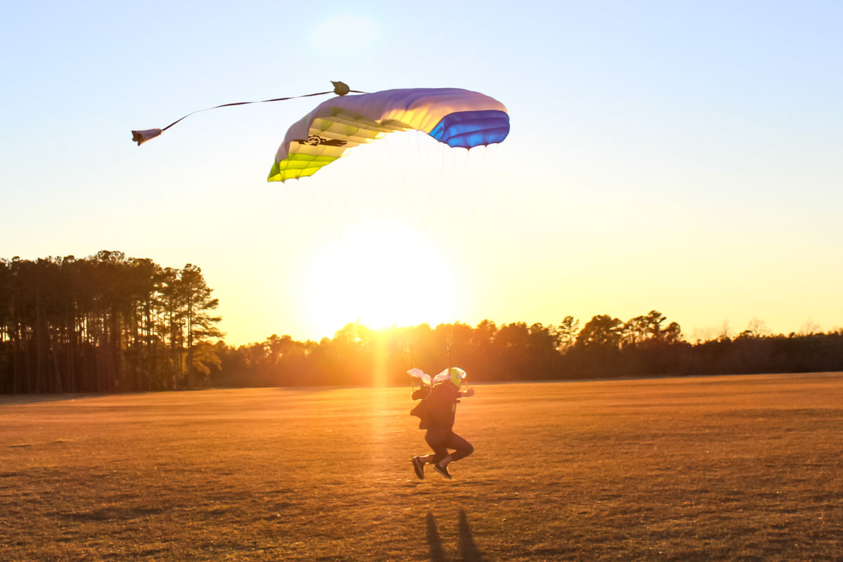 Skydiver landing their parachute at sunset 