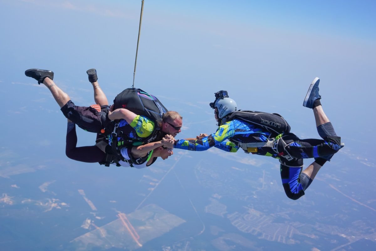 Tandem skydivers in freefall with videographer 