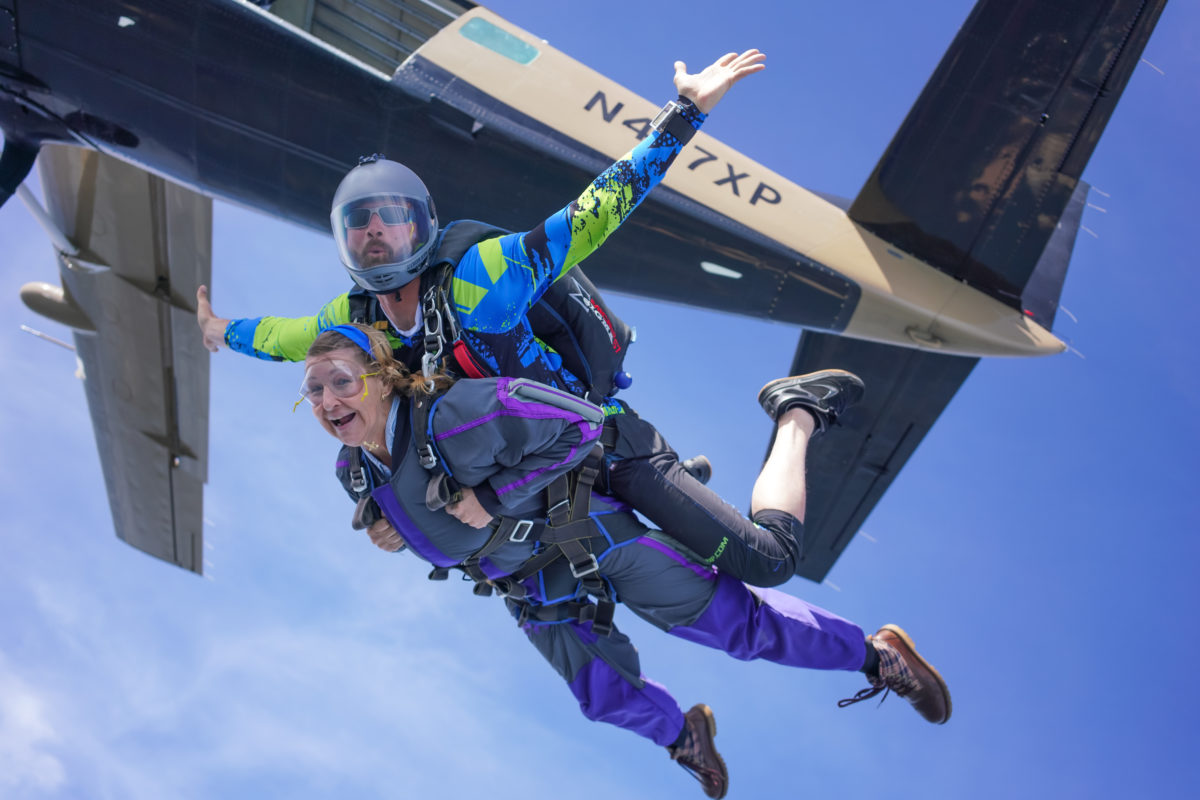 Tandem skydivers exit airplane 