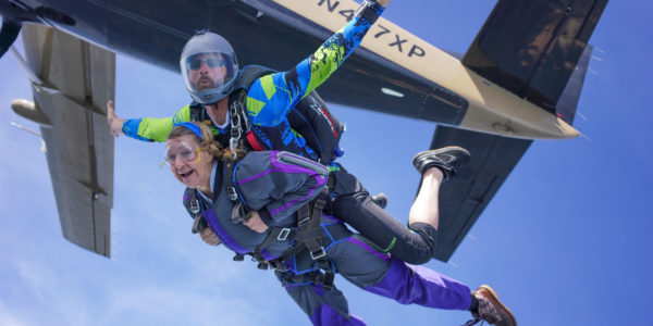 Tandem skydivers exit airplane