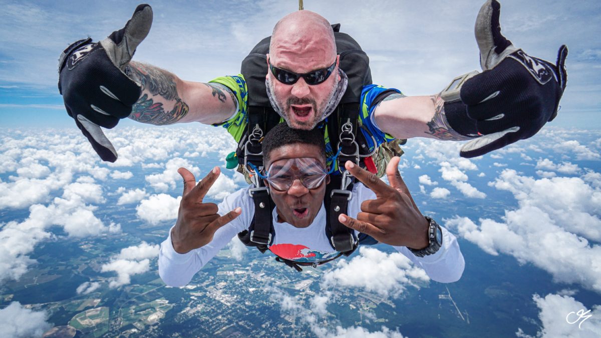 A male pair rocking out a tandem skydive.