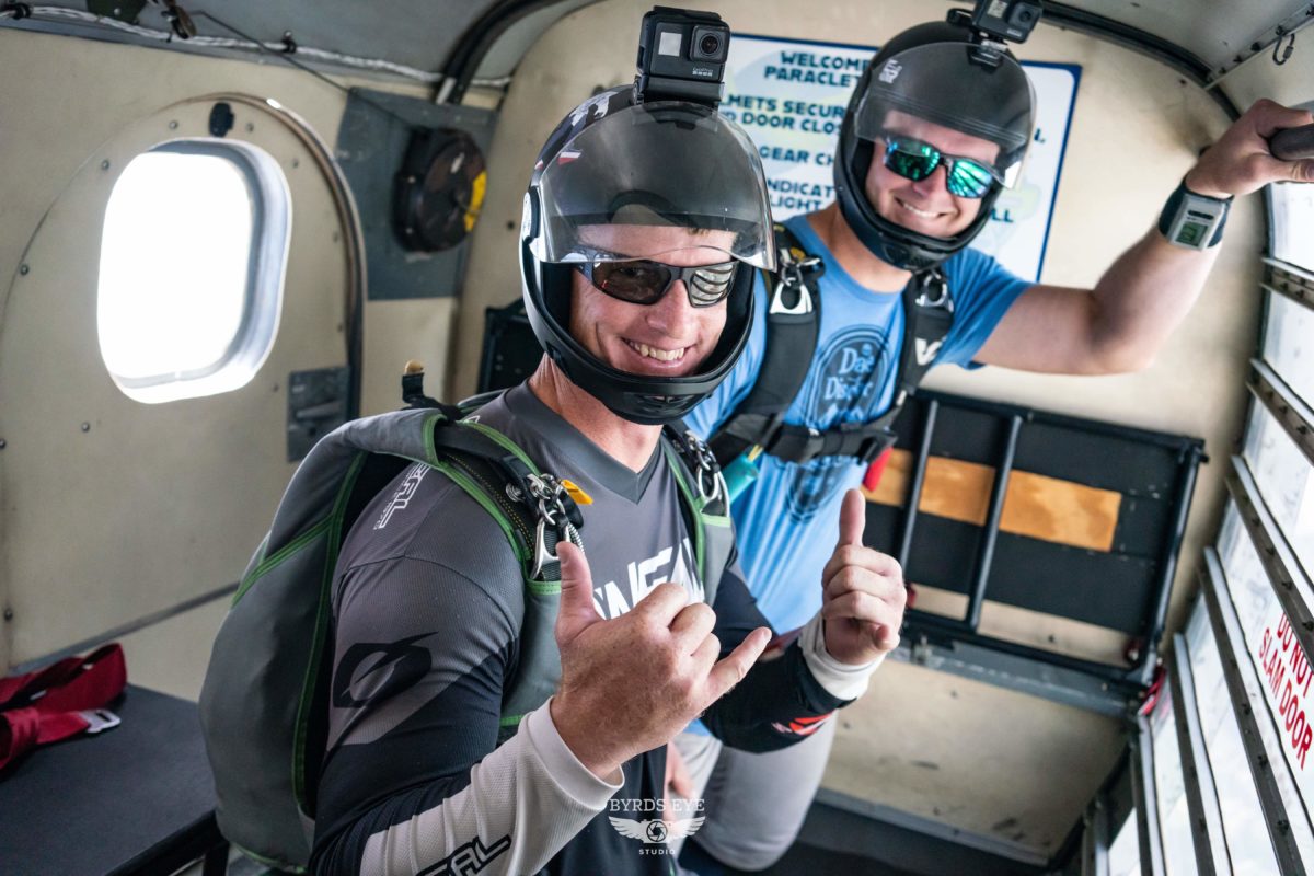 Licensed jumpers giving the hang loose symbol in the jump plane at Skydive Paraclete XP.