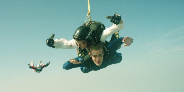 Tandem student and instructor pair with another licensed skydiver behind.
