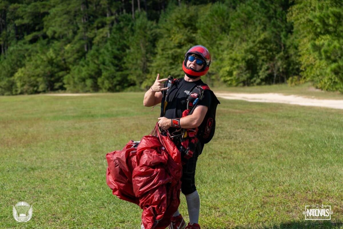 Skydiver holds parachute after competition run 