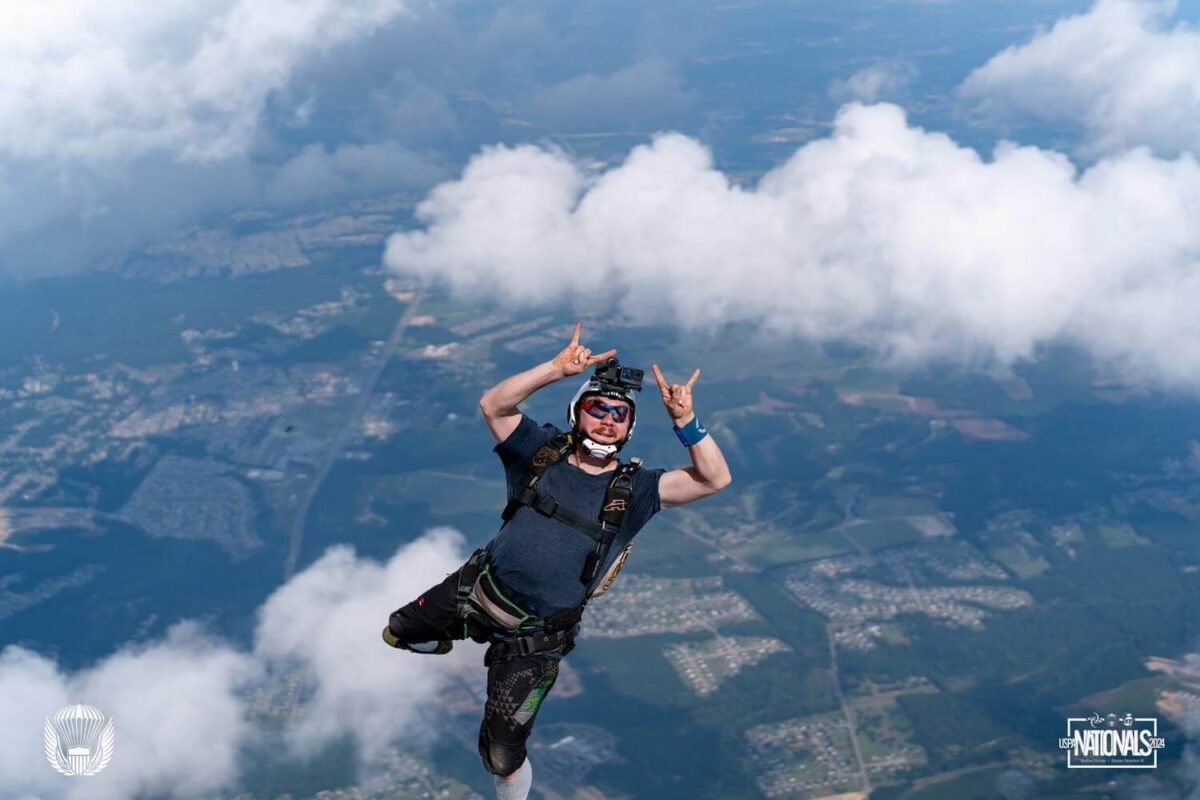 Skydiver entering freefall tossing up 'rock on' hand signal